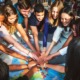 youth thriving, Six reasons to read Teen Centered Civics for Human Thriving_feature: group of teens put hands together over world map