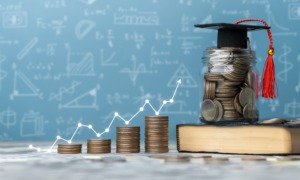 Youth financial education literally pays off_feature: graphic of stacks of coins with line graph going up to jar of coins with graduation cap on top
