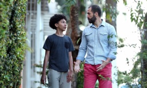 A capstone essay on 50 years of promoting positive youth development _feature: young boy and mentor/father figure walk outdoors while talking
