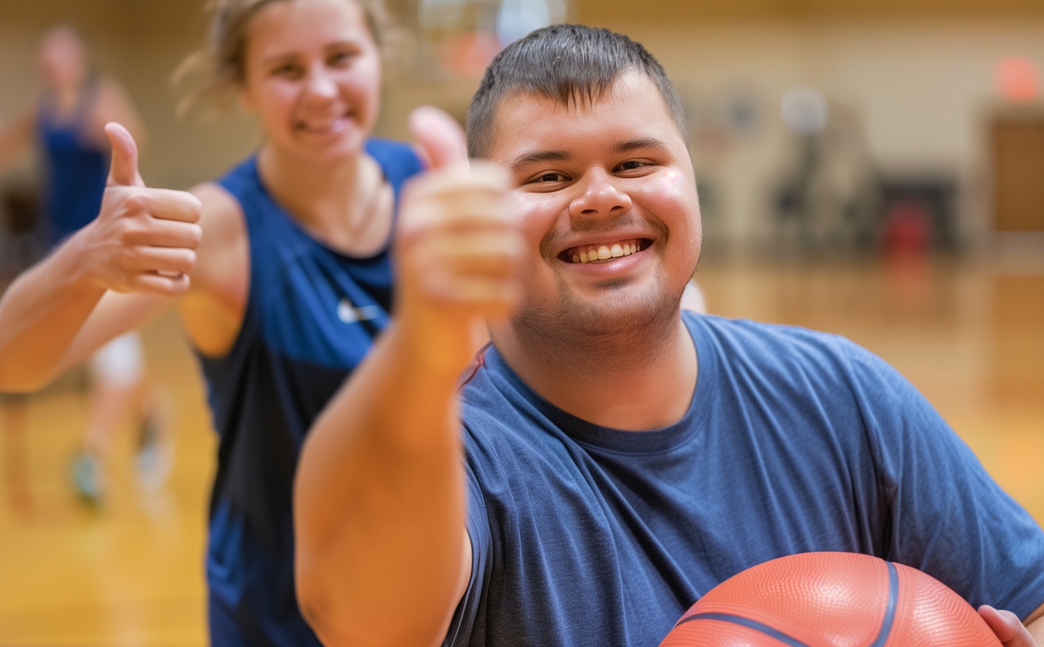 Back to school back to Unified_How your organization can champion inclusion_feature: Young adult with down syndrome smiling and giving a thumbs up while holding a basketball while another person does the same behind