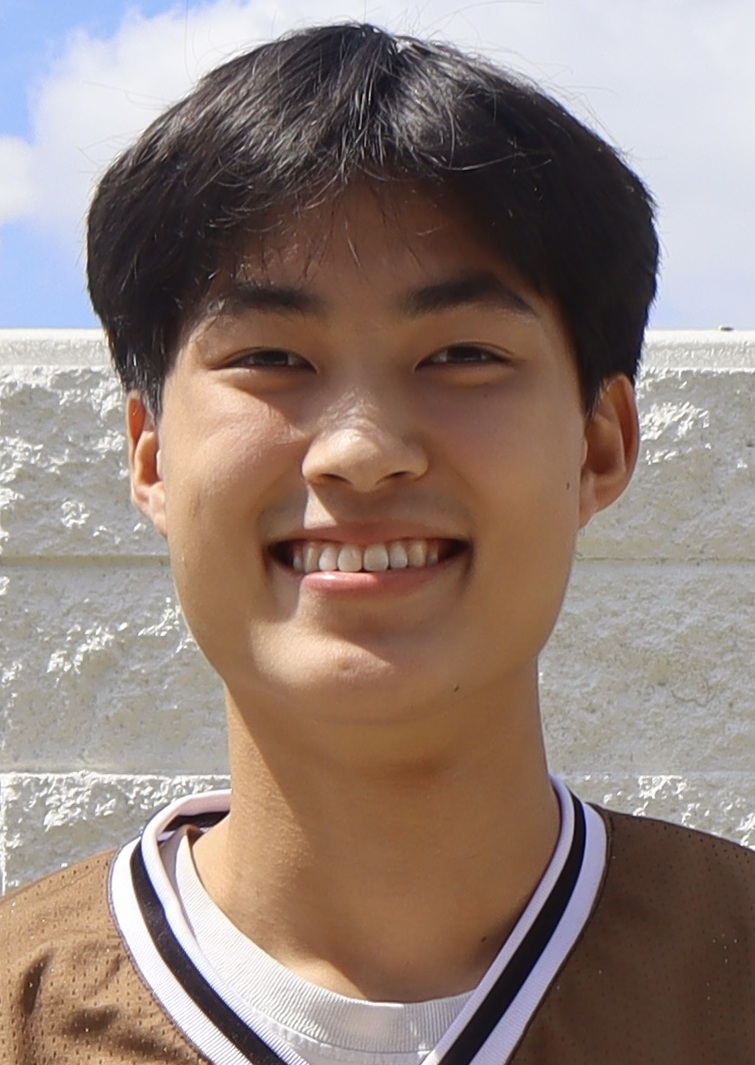 William Kang headshot: smiling Asian man outdoors in front of white brick wall