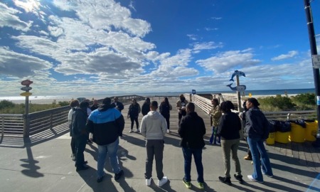 restorative professional development for youth workers_workshop outdoors, connecting to nature_feature: group of people standing outside with blue, partly cloudy sky