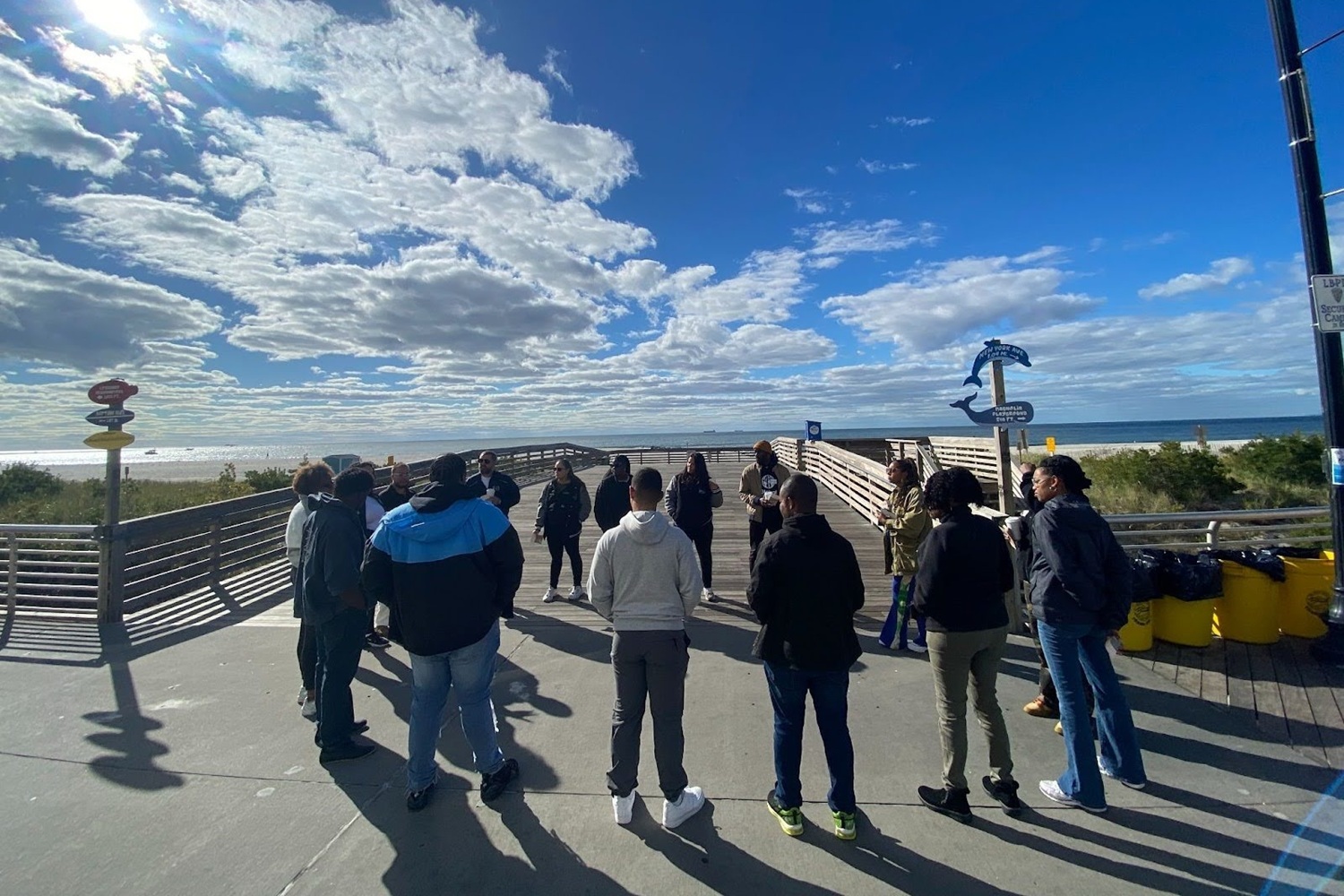 restorative professional development for youth workers_workshop outdoors, connecting to nature_feature: group of people standing outside with blue, partly cloudy sky