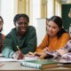 An invitation to learn reflect and act together for equity-centered thriving: group of diverse youth happily works at table together