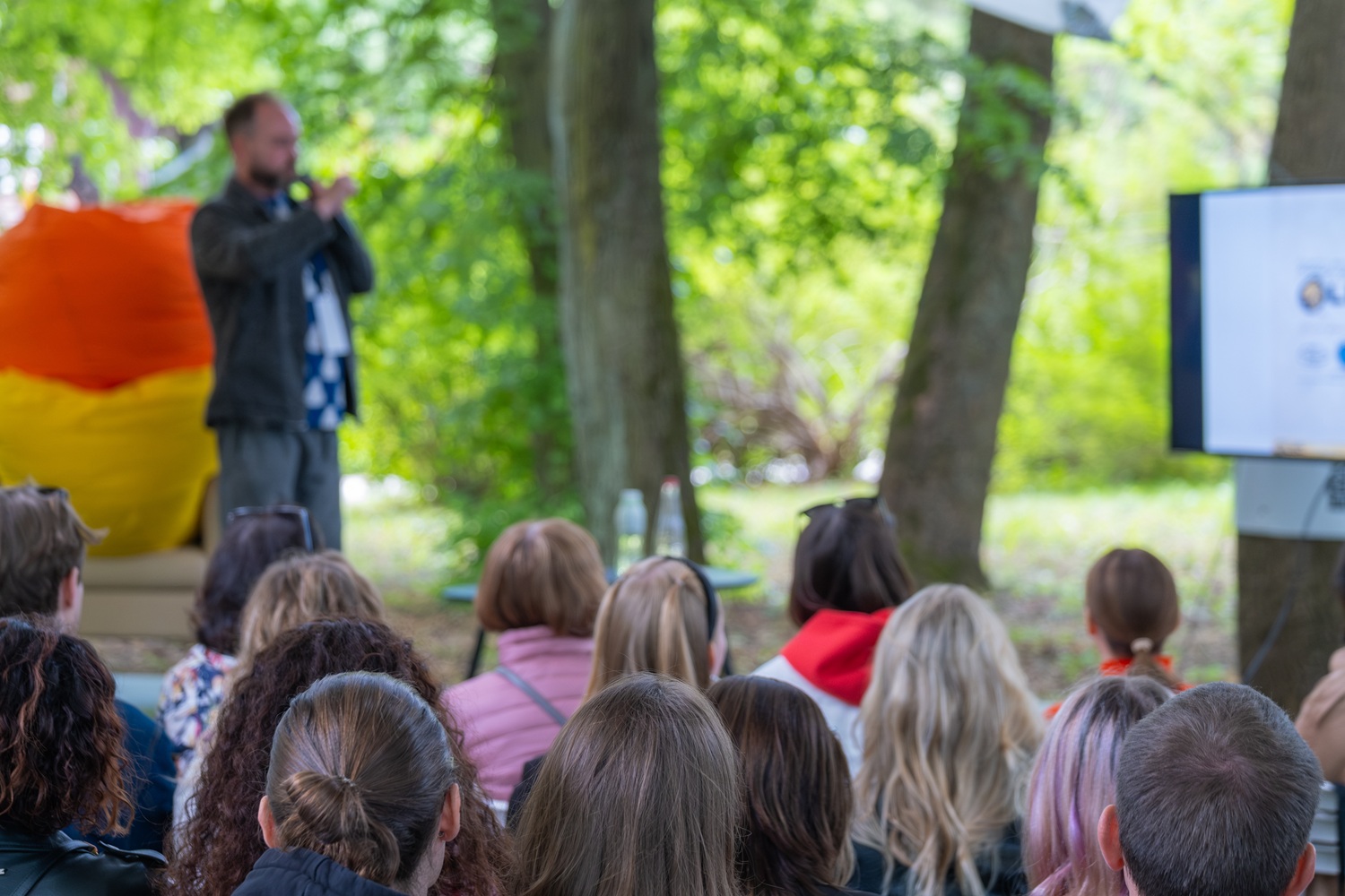 From systems leadership to learning ecosystems stewardship_feature: group of kids watch an educator giving a presentation outside