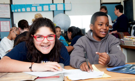 Grants to improve youth mental health through writing and SEL_feature: two happy youths writing and joking at table