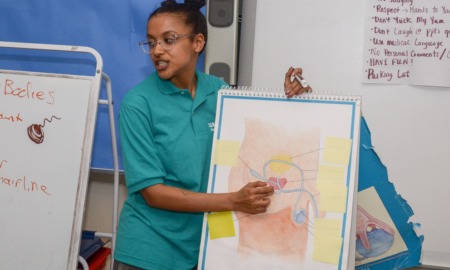 What I learned teaching sex education as a teen, and why every school needs it_feature: young woman points to diagram of sexual organs in front of classroom