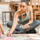 Big Thought ecosystem intermediary behind Dallas City of Learning_feature: young black female artist works on the floor with headphones around neck