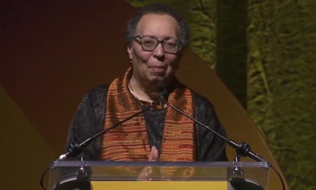 QA_ Karen Pittman _2026 NEA Foundation’s Outstanding Service Public Education Award_older black woman stand at podium with hands clasped in front of her