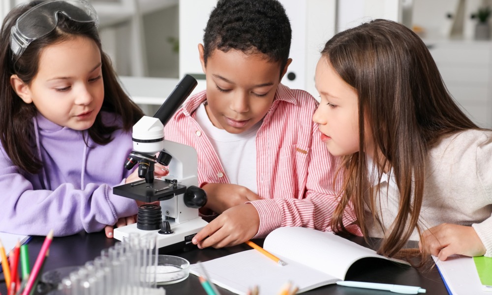 The overlooked link between literacy, STEM and student success_feature: Little children with microscope studying Chemistry in science classroom