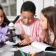 The overlooked link between literacy, STEM and student success_feature: Little children with microscope studying Chemistry in science classroom