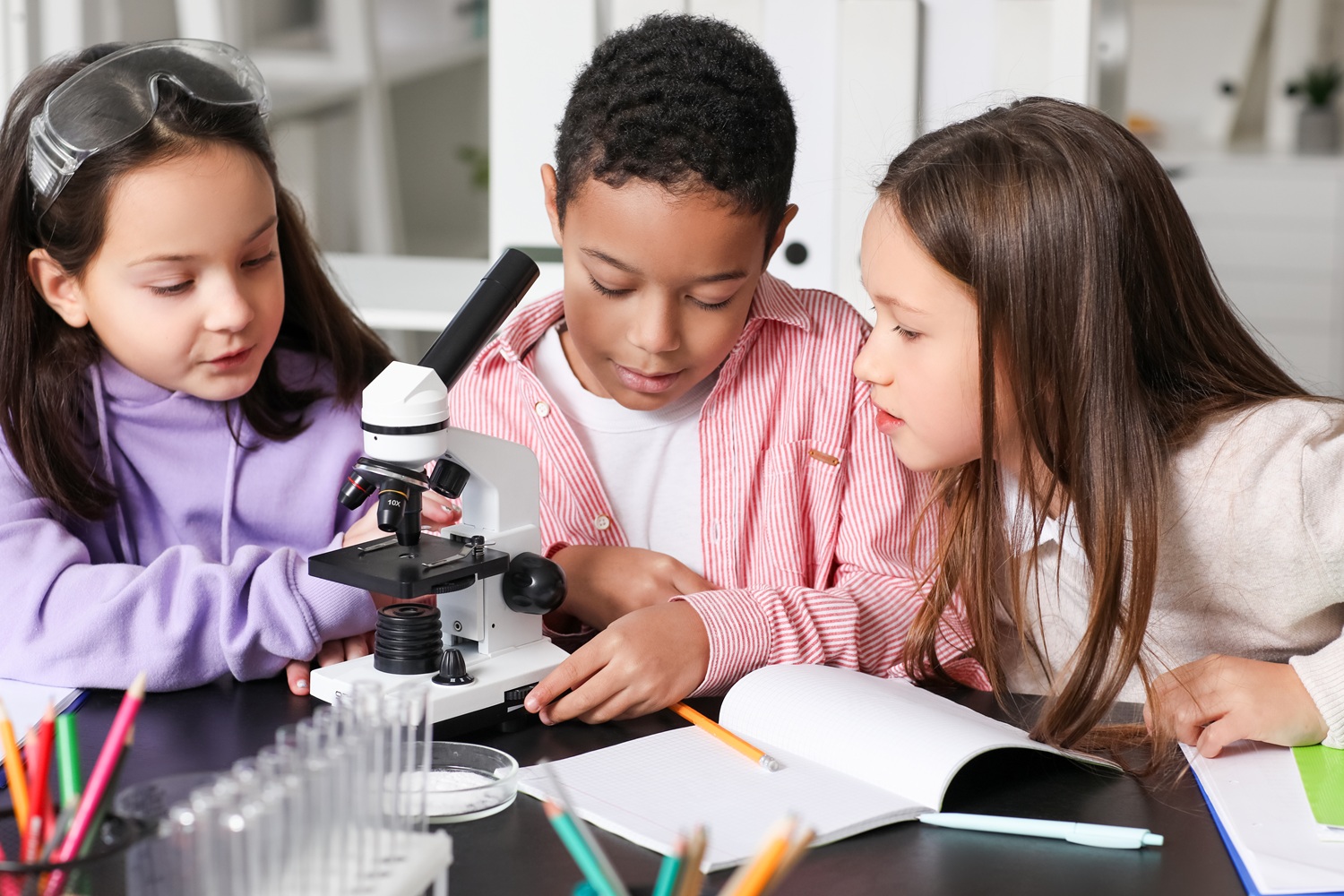 The overlooked link between literacy, STEM and student success_feature: Little children with microscope studying Chemistry in science classroom