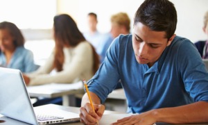 When accomodations exist on paper but not in practice_how ACT testing fails students with disabilities: male high school student taking test on laptop