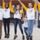 Young scientist challenge project award grants: group of youths in matching shirts and lanyards jumping for joy outdoors