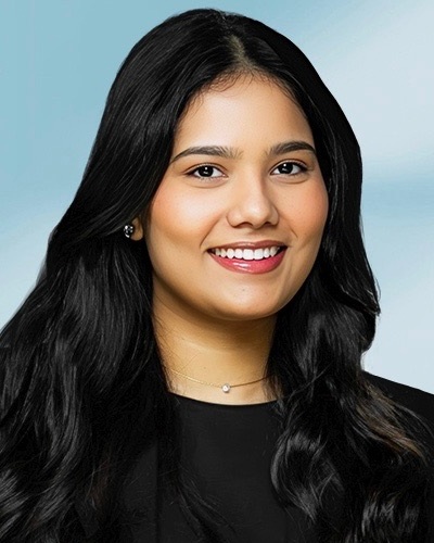 Lubna Sherri headshot: young woman with long dark hair in black shirt