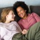 Permanency-without-connection-fails-foster-youth-True-support-means-lasting-relationships_feature: young white girl with black mom smiling at eachother on the couch