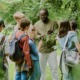 learning environments What John King's teachers were actually doing_feature: group of students listens to black male teacher outdoors teaching them about plants