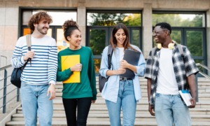 Higher education student support center grants: group of college students happily walking down steps on campus