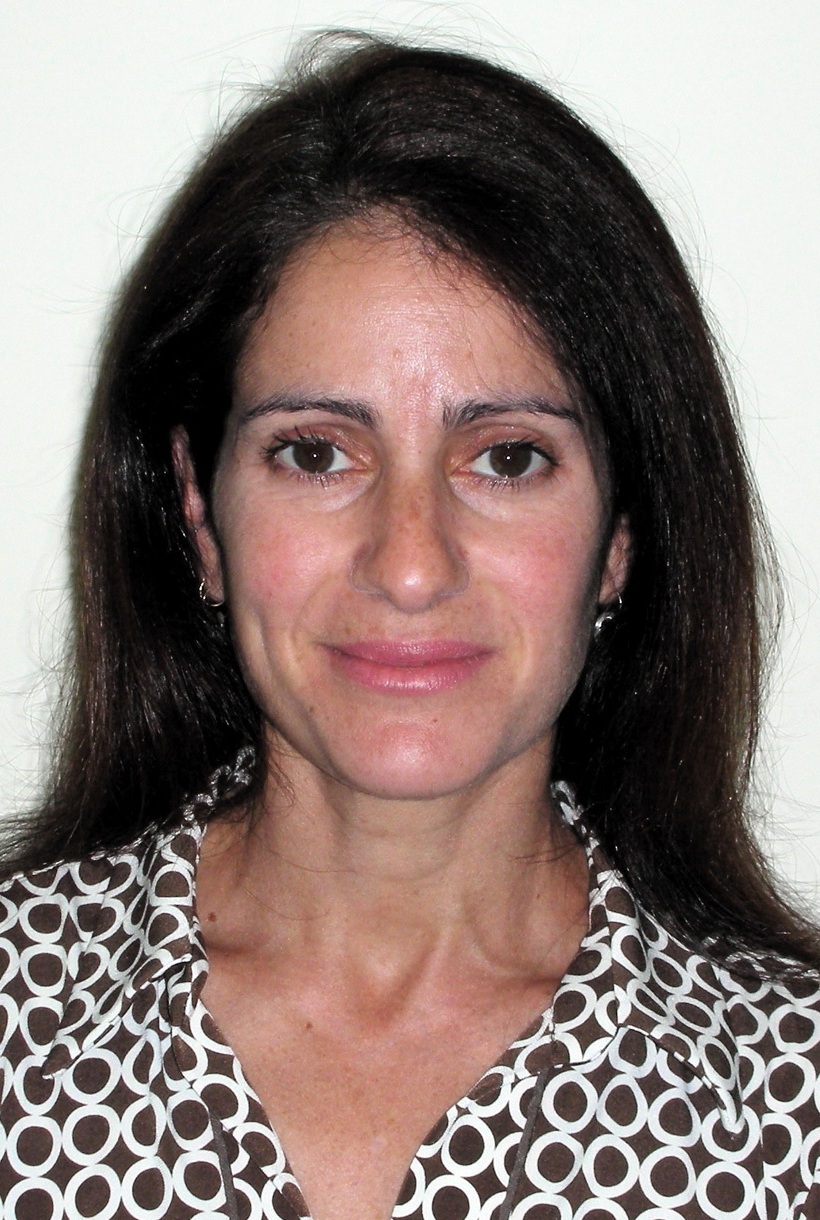 Beth Casarjian headshot: white woman with long dark hair wearing black and white patterned shirt in front of white background