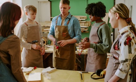 Social capital From participants to partners Rethinking the role of alumni in youth programs_feature: group of youth learning woodworking from young instructor