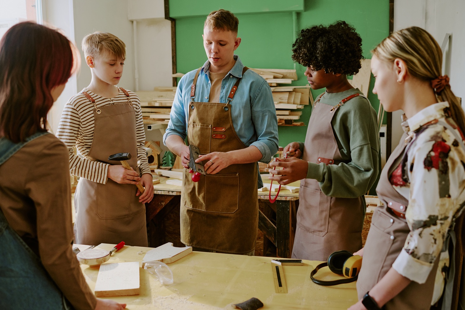 Social capital From participants to partners Rethinking the role of alumni in youth programs_feature: group of youth learning woodworking from young instructor