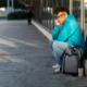I lived in a coat closet to stay in college, student homelessness _feature: unhappy college student sits on sidewalk with backpack