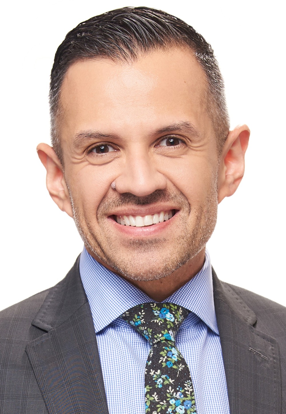 Joaquin Tamayo headshot: light-skinned man with short hair wearing suit and colorful tie against white background