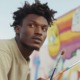Keeping it real_feature3: young black male artist working on outdoor mural