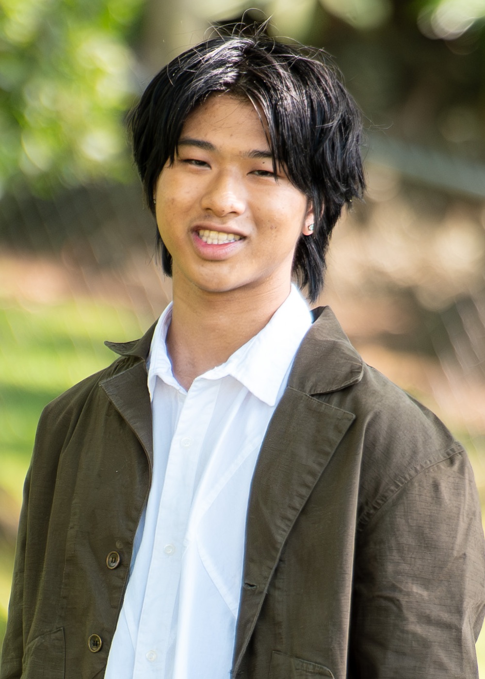 Maxwell Shei headshot: young asian man with dark hair wearing a collared shirt and jacket outdoors