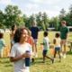 The most important moments of abuse prevention aren't always on the schedule_feature: group of children having water break at summer camp with camp staff
