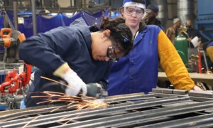 Why America must invest in apprenticeships — now_feature: a young metal working apprentice works in a metal shop