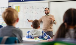 English learning educator professional development grants_feature: male teacher showing children English letters