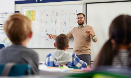 English learning educator professional development grants_feature: male teacher showing children English letters