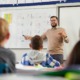 English learning educator professional development grants_feature: male teacher showing children English letters