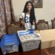 How Cureco is redefining youth-led health advocacy, youth-led advocacy_feature: teen girl with long dark hair stand in front of boxes of medical supplies on table