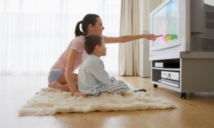PreK-5 educational media development and dissemination grants_feature: a mother points to something on tv screen as young boy watches