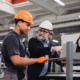 Skilled trades training and capacity-building program grants: older tradesman teaches young male and female in training on factory floor