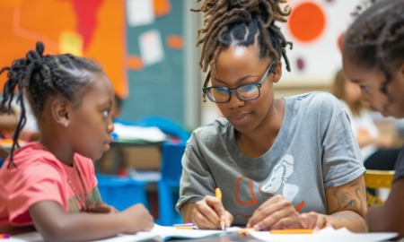 What if we treat staff development as part of our core mission_feature: young black woman helps two young black children at table in youth program