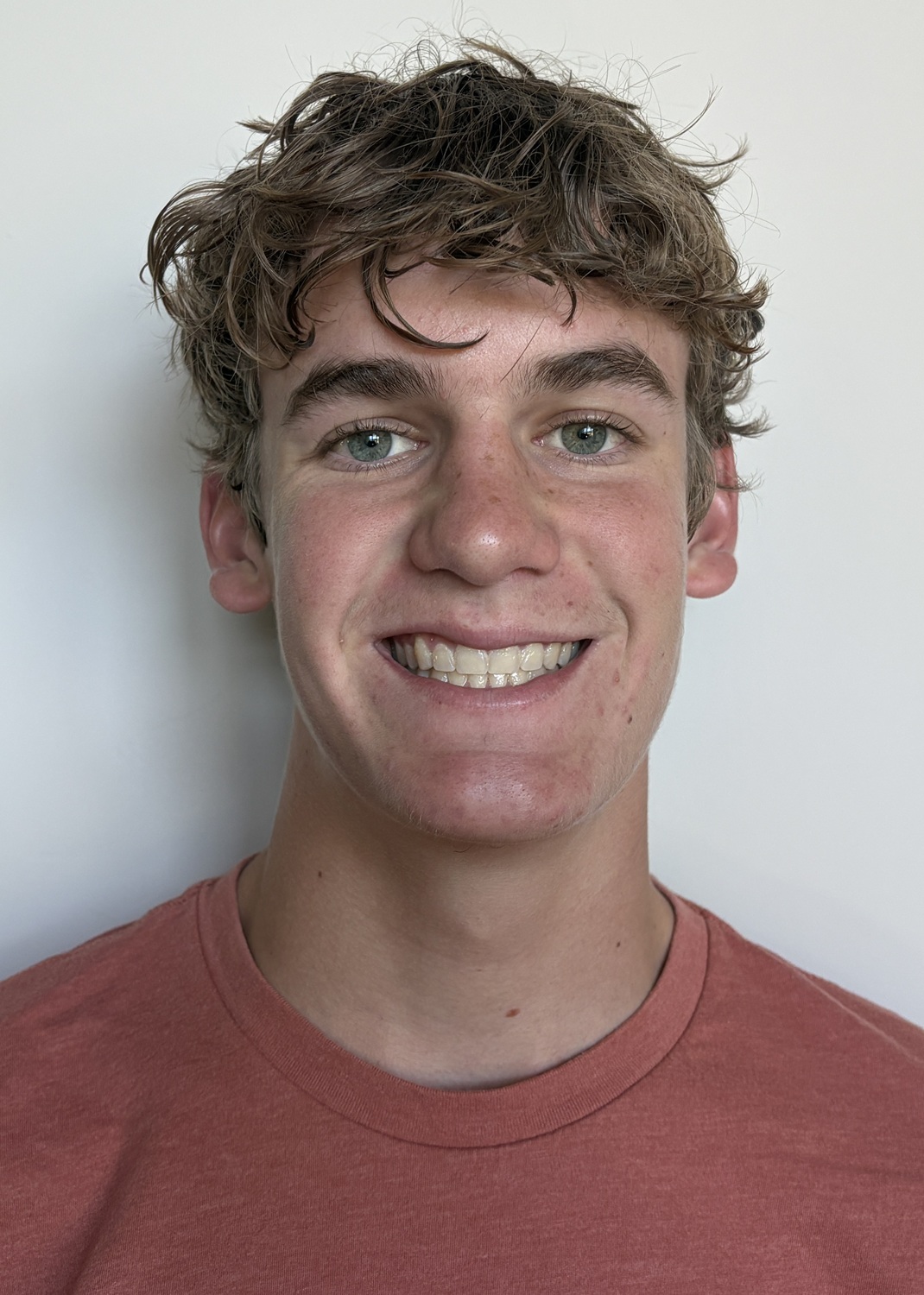 Will Moffett headshot: white teen boy smiling while wearing red shirt in front of white background