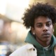 Young people aren't losing trust-they're giving up_feature: young black man in hoodie and jacket outdoors looking sad and disappointed