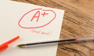 A for no effort-high school grade inflation_feature: a paper on wooden desk with "A+" written on it
