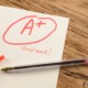 A for no effort-high school grade inflation_feature: a paper on wooden desk with "A+" written on it