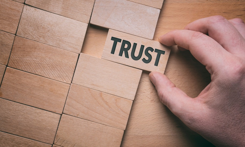 Exploring the trust gap-An open invitation_feature: Trust word written on wooden block. Building trust business concept.
