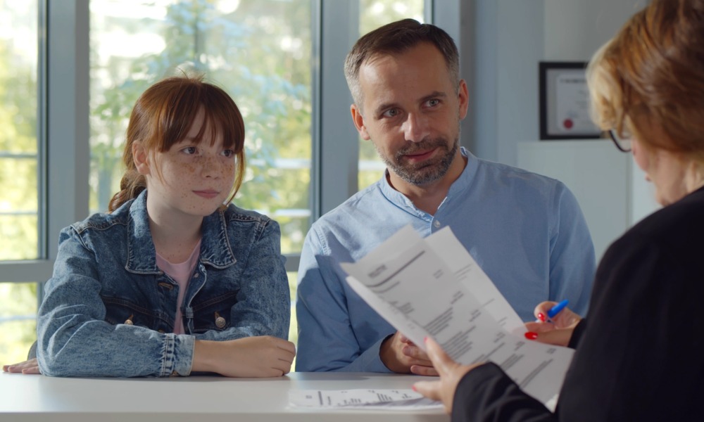 In and beyond the school day-Expanding access to the behavioral supports that shape young people’s futures_feature2: young red haired girl and father meet with education professional