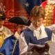QA-As America turns 250, SPIRIT SERIES teaches democracy through theater_feature2: a young boy reads aloud during a performance in founding era garb