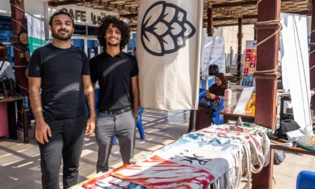 The skills are there-The opportunity is not-What the future of work is missing_feature: two young men stand behind table of clothing for sale at outdoor shop