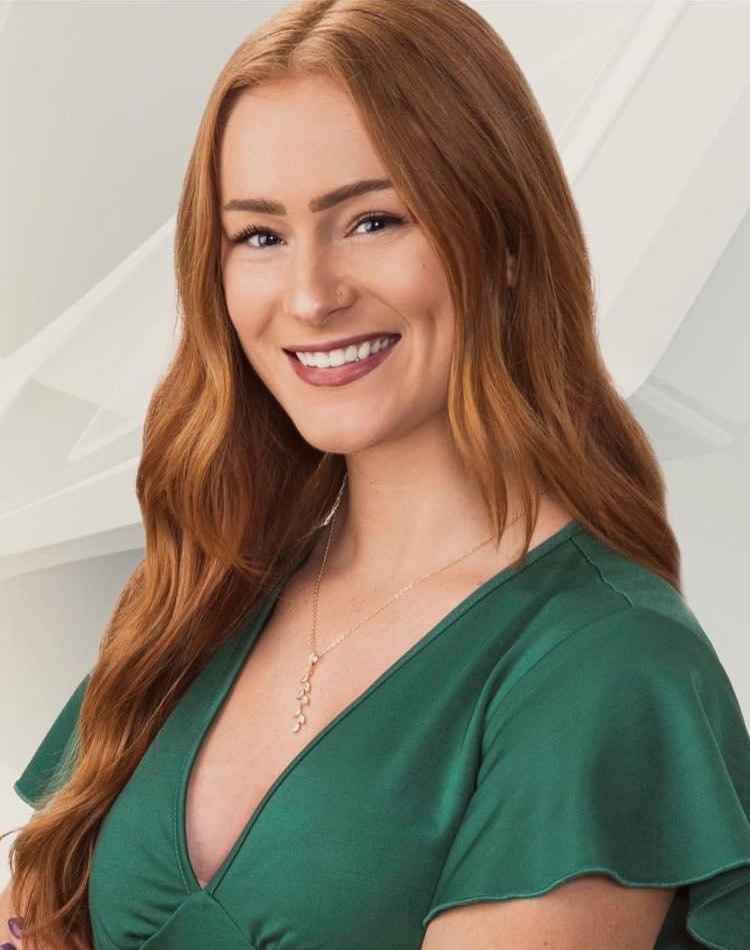 Emily Allegrucci headshot: young white woman with long red hair wearing green blouse