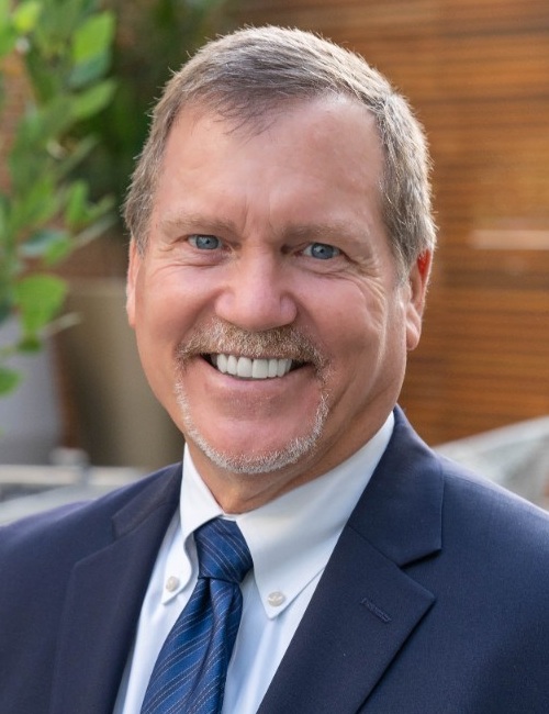 Jack Kline headshot: middle-aged white man with short light hair and short goatee wearing a suit and tie outdoors