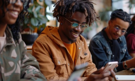 The problem isnt access its application-What teens actually need from financial education _feature2: group of black youths happily working on phones while using financial planning app