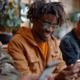 The problem isnt access its application-What teens actually need from financial education _feature2: group of black youths happily working on phones while using financial planning app